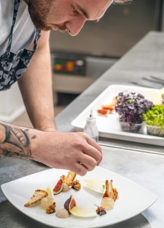 the-chef-is-garnishing-appetizer-dish-PDHYM4B